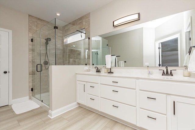 bathroom with a shower with door and vanity