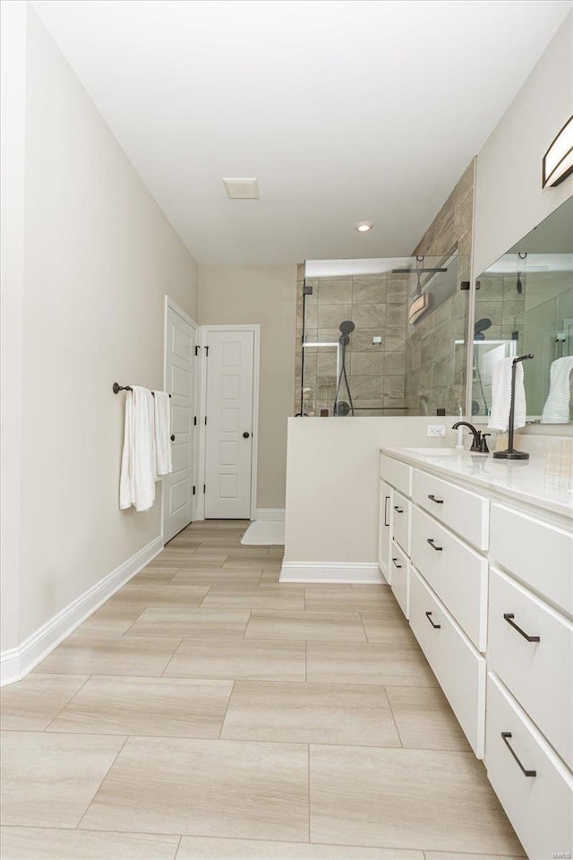 bathroom with vanity and a tile shower