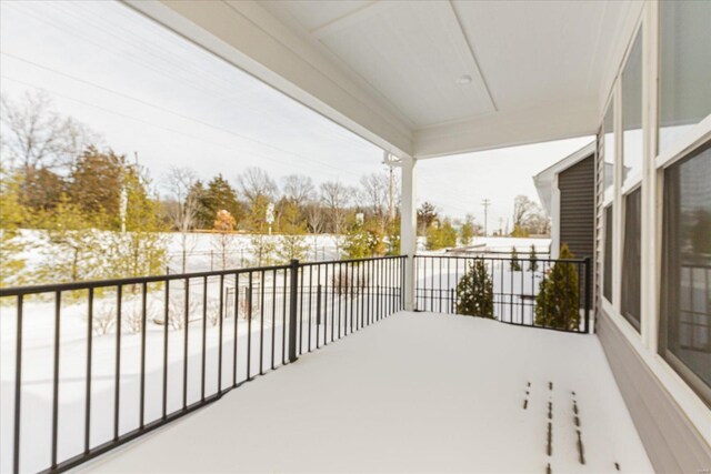 view of snow covered back of property