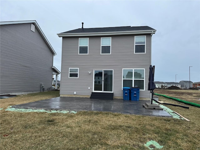 rear view of property featuring a lawn and a patio