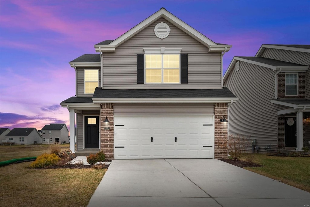 view of front property with a garage and a lawn