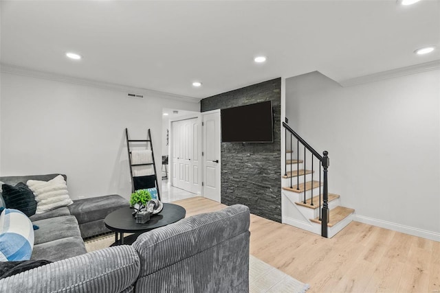 living room with light wood-type flooring and crown molding