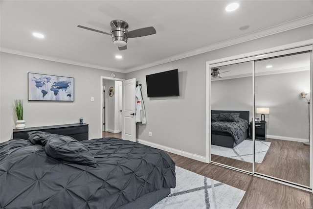 bedroom with ceiling fan, a closet, crown molding, and wood-type flooring