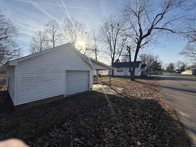 exterior space featuring a garage and an outbuilding