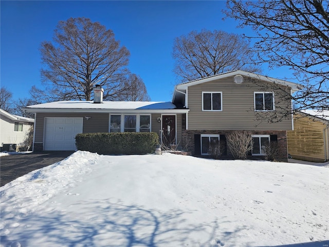 tri-level home featuring a garage and central AC