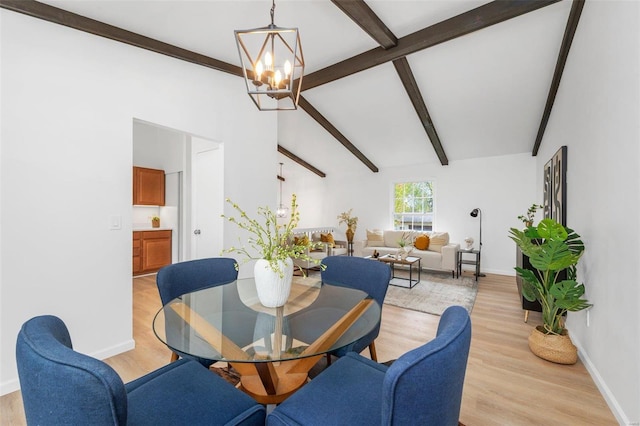 dining area featuring vaulted ceiling with beams, a notable chandelier, and light hardwood / wood-style floors