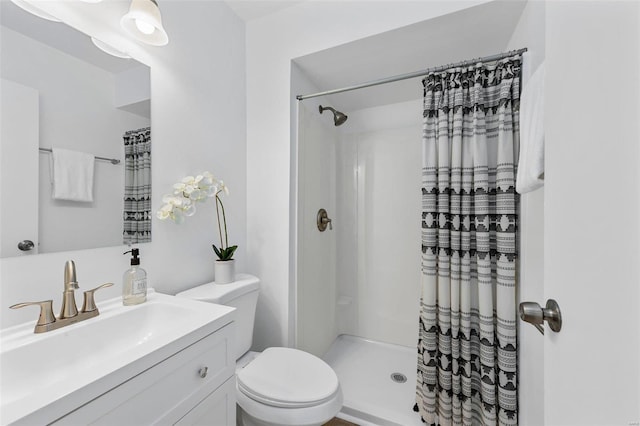 bathroom with toilet, vanity, and a shower with curtain