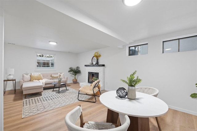 dining area featuring a fireplace and wood-type flooring