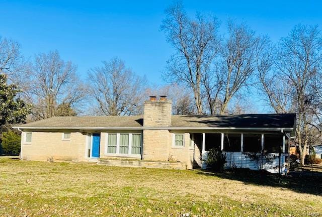 rear view of house featuring a lawn