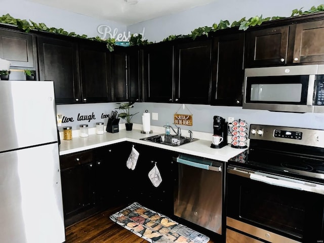 kitchen featuring sink, appliances with stainless steel finishes, and dark wood-type flooring