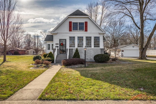 view of front of home with a garage, an outbuilding, and a front lawn