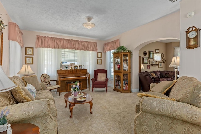 carpeted living room featuring a textured ceiling