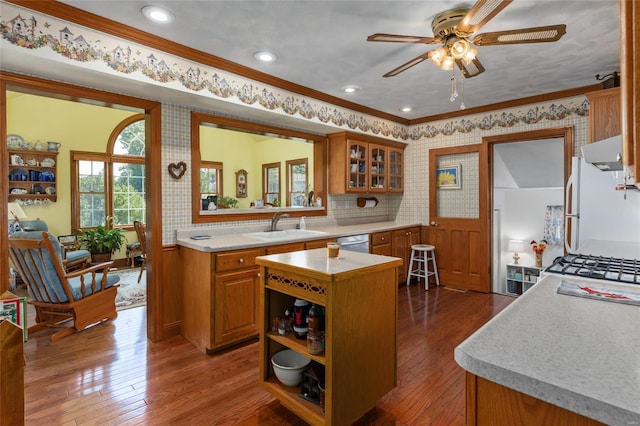 kitchen with dark hardwood / wood-style floors, a kitchen island, white refrigerator, and crown molding