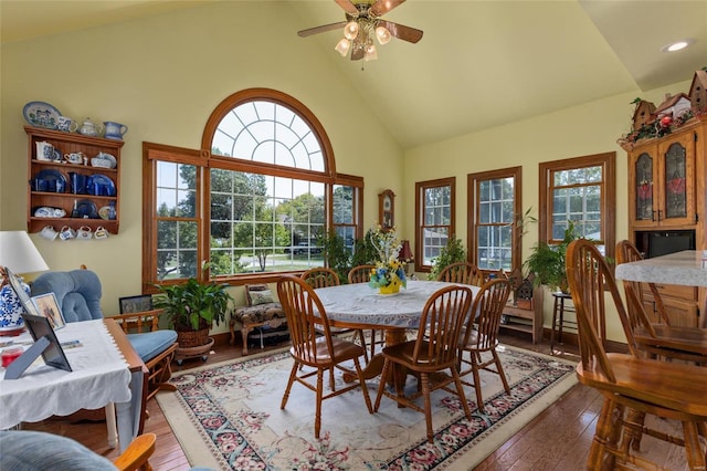 dining space with hardwood / wood-style flooring, plenty of natural light, ceiling fan, and high vaulted ceiling