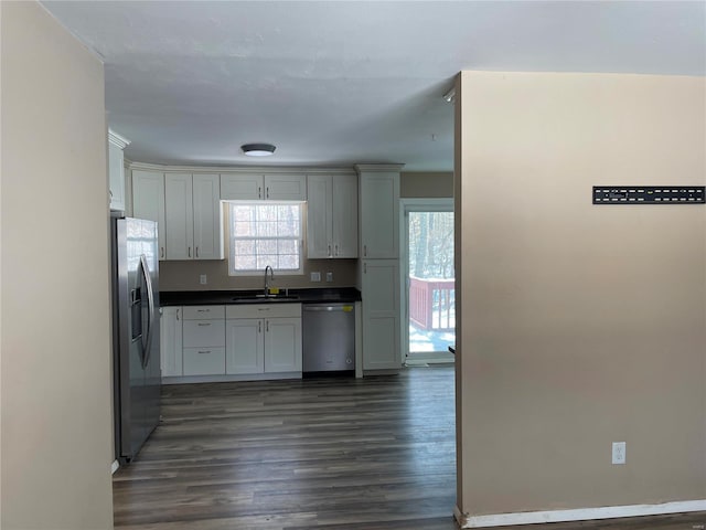 kitchen with appliances with stainless steel finishes, dark hardwood / wood-style flooring, and sink