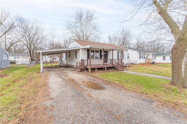 view of front of house featuring a carport, a front lawn, and covered porch