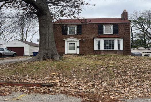 view of front of property featuring a garage and an outdoor structure