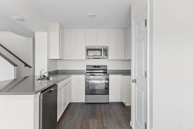 kitchen featuring sink, white cabinetry, stainless steel appliances, and dark wood-type flooring