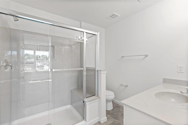 bathroom with vanity, toilet, and a shower with shower door