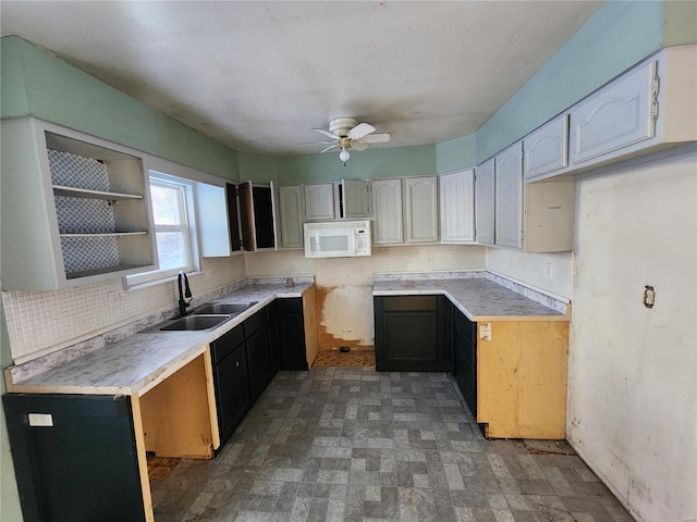 kitchen with ceiling fan, sink, white cabinets, and decorative backsplash