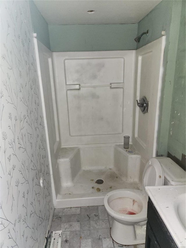 bathroom with toilet, a shower, and vanity