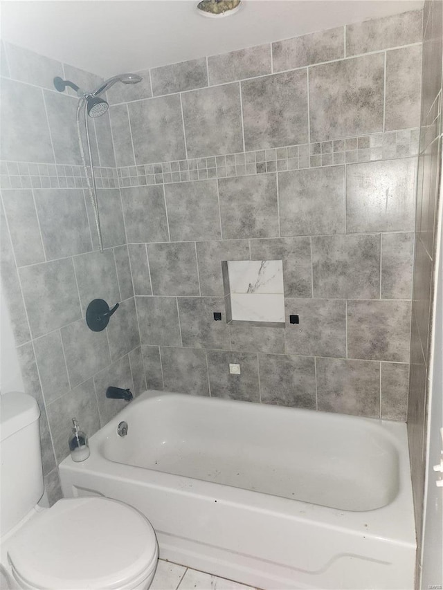 bathroom with toilet and tiled shower / bath combo