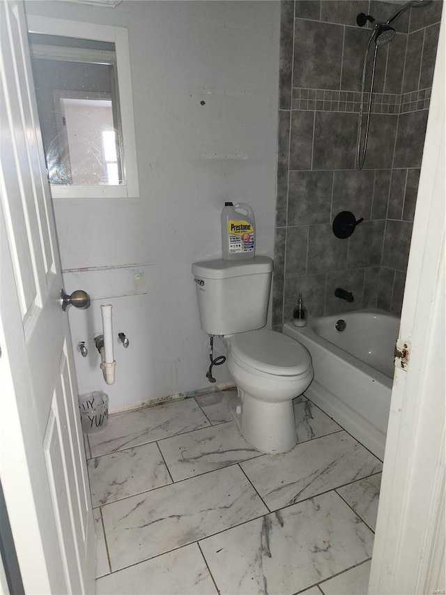 bathroom featuring toilet and tiled shower / bath