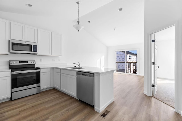 kitchen with white cabinets, appliances with stainless steel finishes, kitchen peninsula, and sink