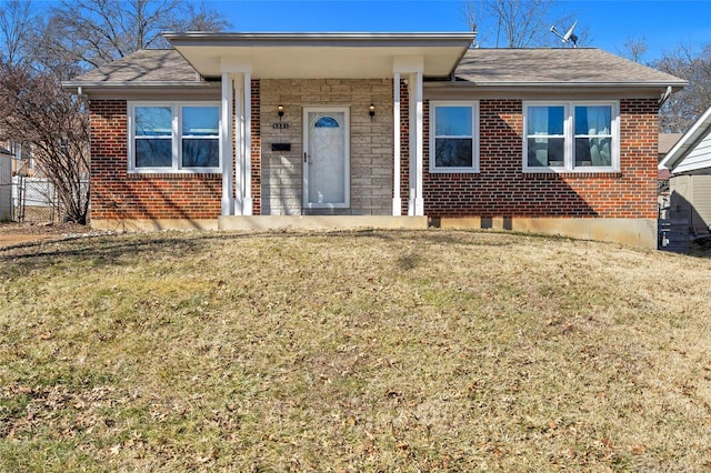 single story home featuring a front yard and brick siding