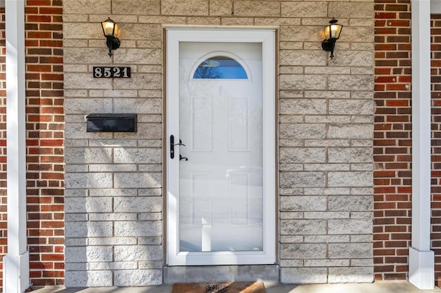 entrance to property featuring brick siding