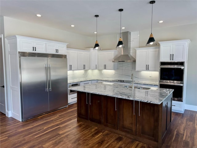 kitchen featuring white cabinetry, a kitchen island with sink, pendant lighting, and appliances with stainless steel finishes