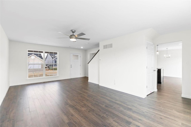 unfurnished living room featuring ceiling fan with notable chandelier and dark hardwood / wood-style floors