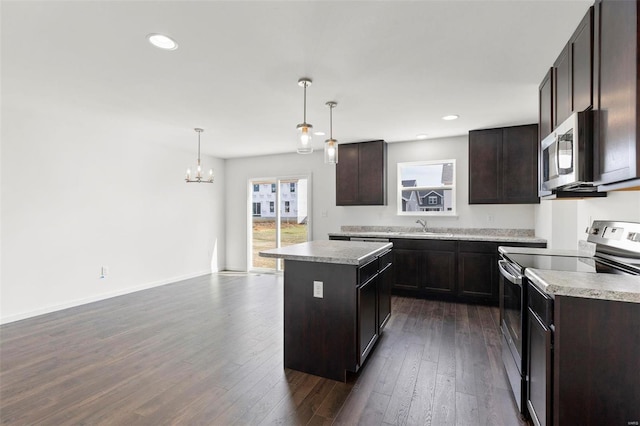 kitchen with decorative light fixtures, dark hardwood / wood-style floors, a notable chandelier, a kitchen island, and stainless steel appliances