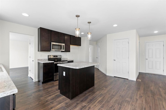 kitchen featuring dark wood-type flooring, pendant lighting, a center island, and stainless steel appliances