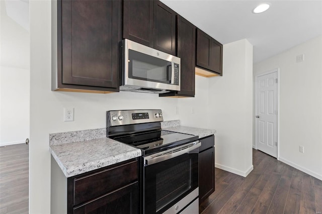 kitchen with dark hardwood / wood-style flooring, dark brown cabinetry, and appliances with stainless steel finishes