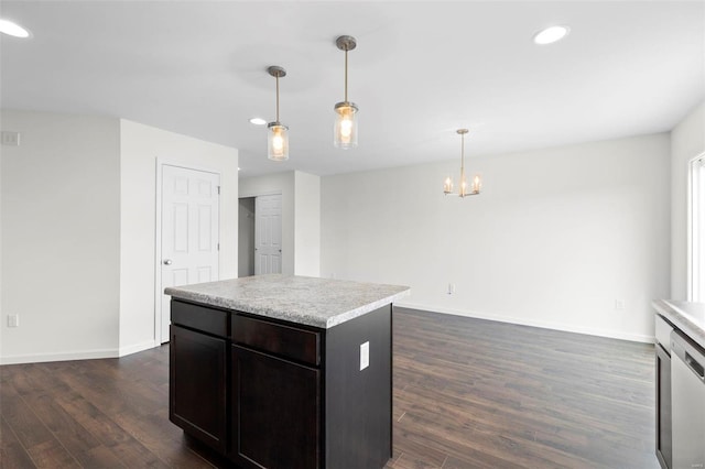 kitchen featuring dark wood-type flooring, stainless steel dishwasher, decorative light fixtures, a kitchen island, and dark brown cabinetry