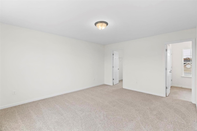 unfurnished room featuring light colored carpet