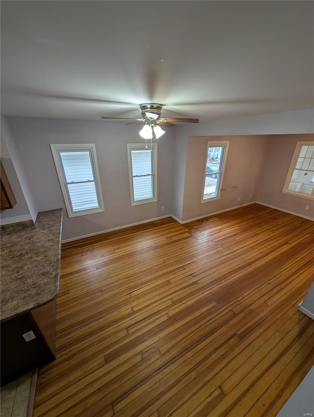 unfurnished living room with hardwood / wood-style floors and ceiling fan