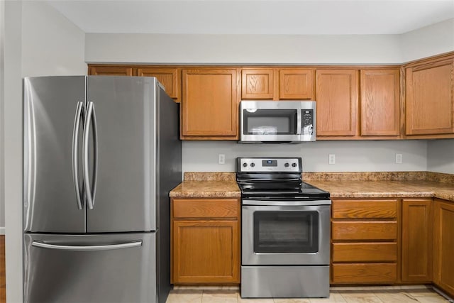 kitchen with light tile patterned flooring and stainless steel appliances