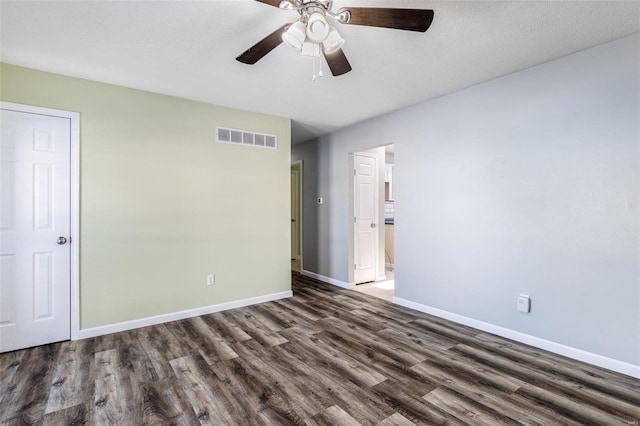 unfurnished bedroom with ceiling fan and dark wood-type flooring