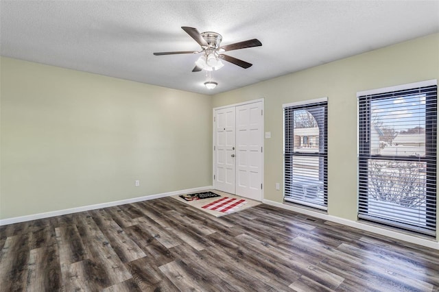 interior space with a textured ceiling, dark hardwood / wood-style flooring, and ceiling fan