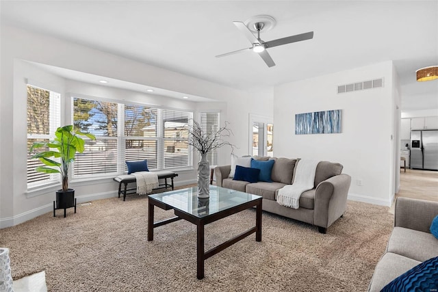 living area with a healthy amount of sunlight, visible vents, and baseboards