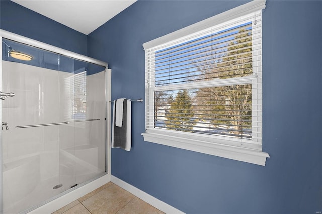 bathroom with tile patterned floors, baseboards, and a shower stall