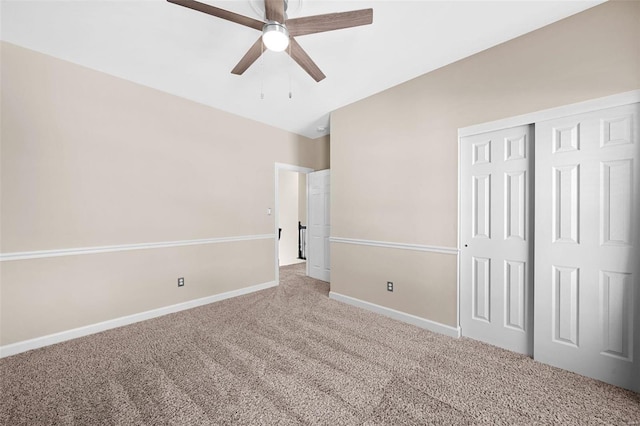 unfurnished bedroom with a closet, carpet, baseboards, ceiling fan, and vaulted ceiling