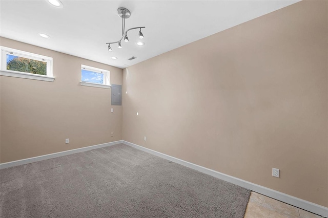 unfurnished room with visible vents, baseboards, electric panel, recessed lighting, and light carpet