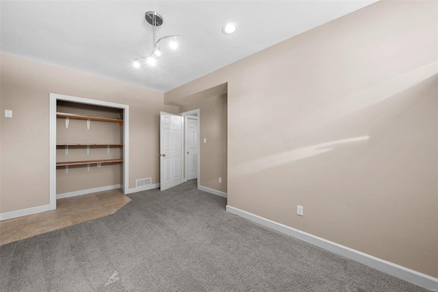 unfurnished bedroom featuring a closet, baseboards, visible vents, and carpet floors