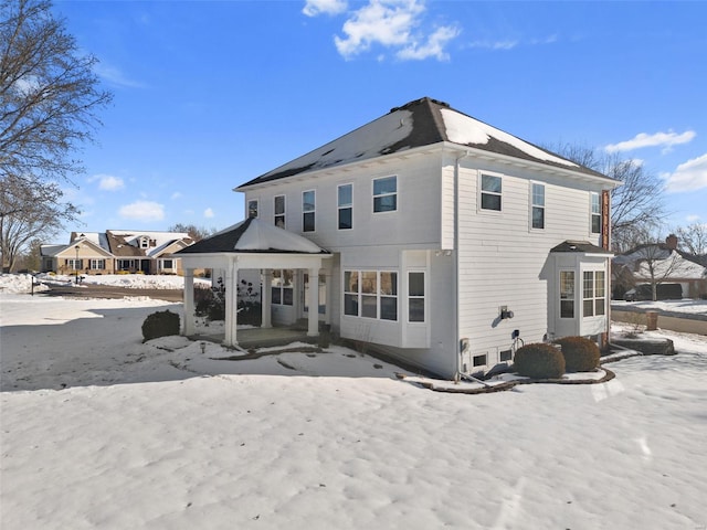 snow covered house featuring a patio