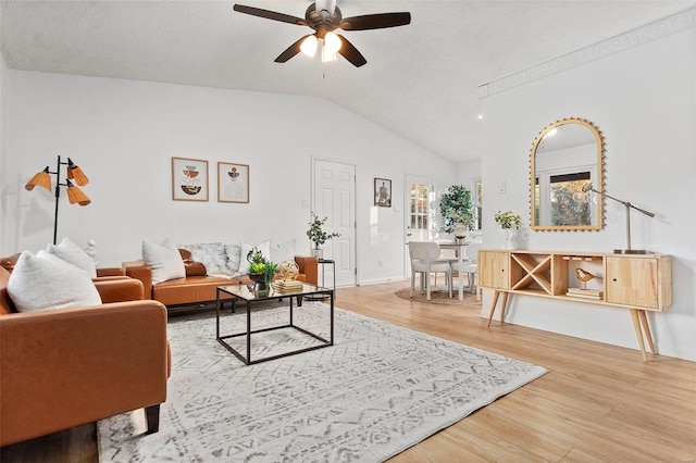 living room featuring ceiling fan, a textured ceiling, hardwood / wood-style flooring, and vaulted ceiling