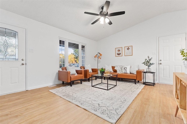 living room featuring lofted ceiling, ceiling fan, and light wood-type flooring