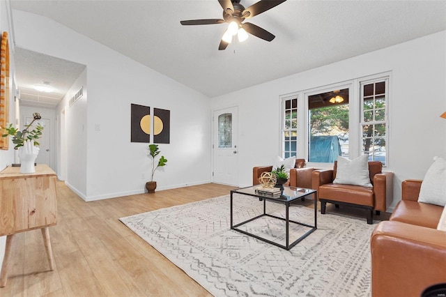 living room featuring lofted ceiling, light wood-type flooring, and ceiling fan